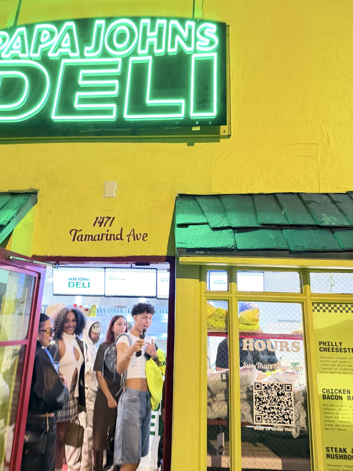 Guests gathered outside a neon-lit storefront during an evening retail customization pop-in